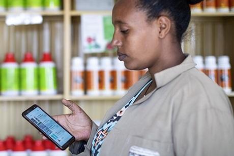 Eine Frau steht vor einem Regal mit Produkten und nutz mittels ihres Smartphones "Lersha".