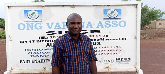 Sanon, Koordinator von VARENA ASSO, vor dem Straßenschild von  VARENA ASSO.