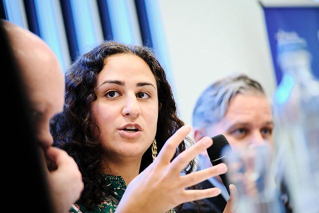 Frau redet und gestikuliert mit einer Hand 