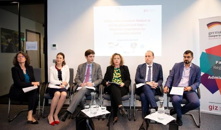 Personen sitzen nebeneinander auf Stühlen