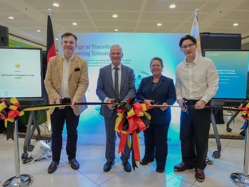 Verteter:innen der Deutschen Botschaft Manila und GIZ Philippinen durchschneiden ein Band auf der Wanderausstellung "Energy in Transition - Powering Tomorrow".