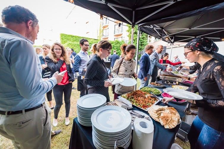 Personen stehen an einem Essenstand an