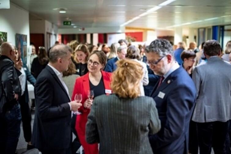 Viele Personen stehen in einem Raum verteilt