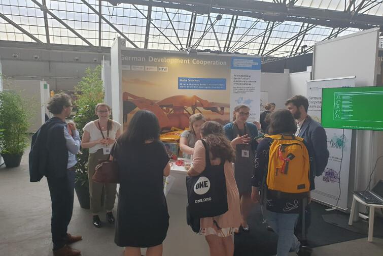 Mehrere Menschen stehen vor einem Stand