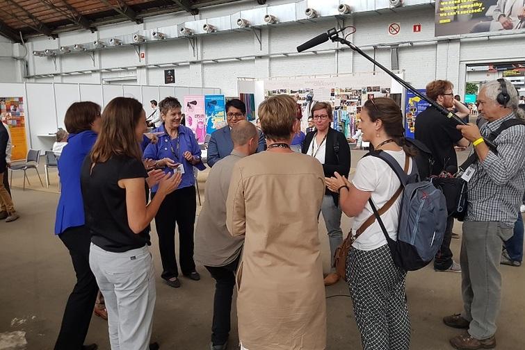 Kamera Team steht in Mitten eines Menschenkreises