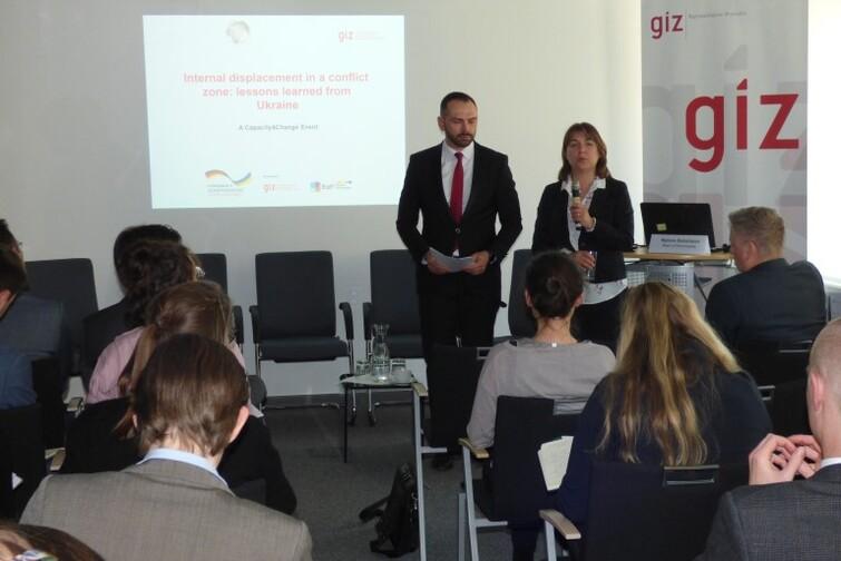 Ein Mann und eine Frau stehen vor einem Publikum