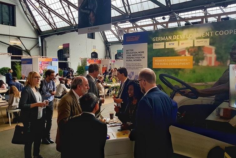 Personen stehen um einen Stand herum