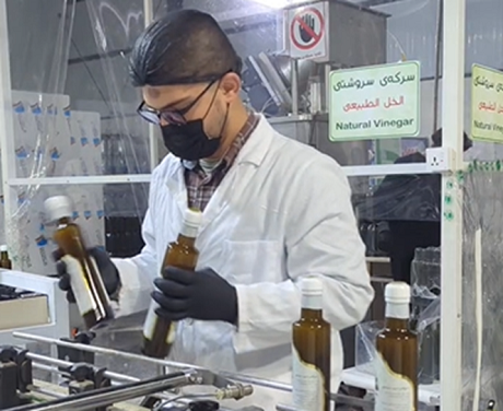 An factory employee sorting bottles 
