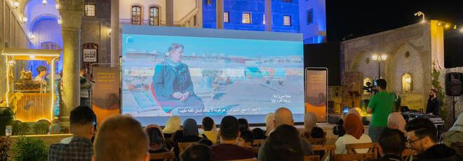 People watching a movie at an open air cinema