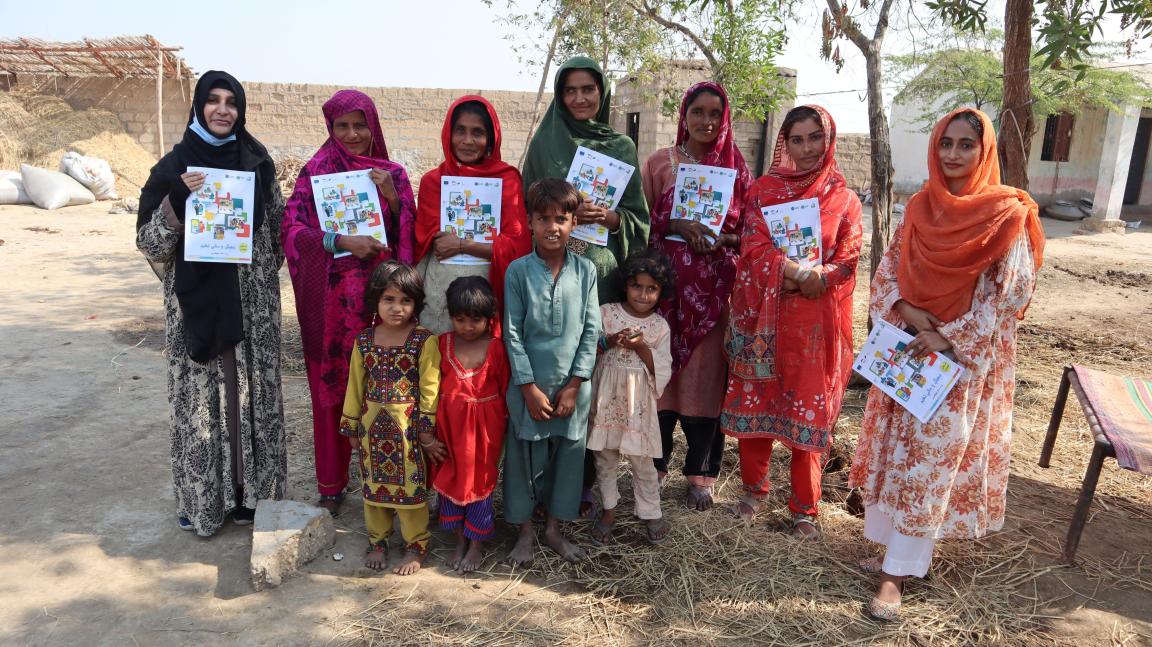 Group picture of local Sindhi women holding the digital financial literacy manual