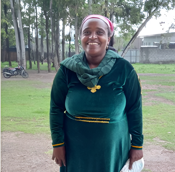 A woman wearing green dress, a green scarf and smiling