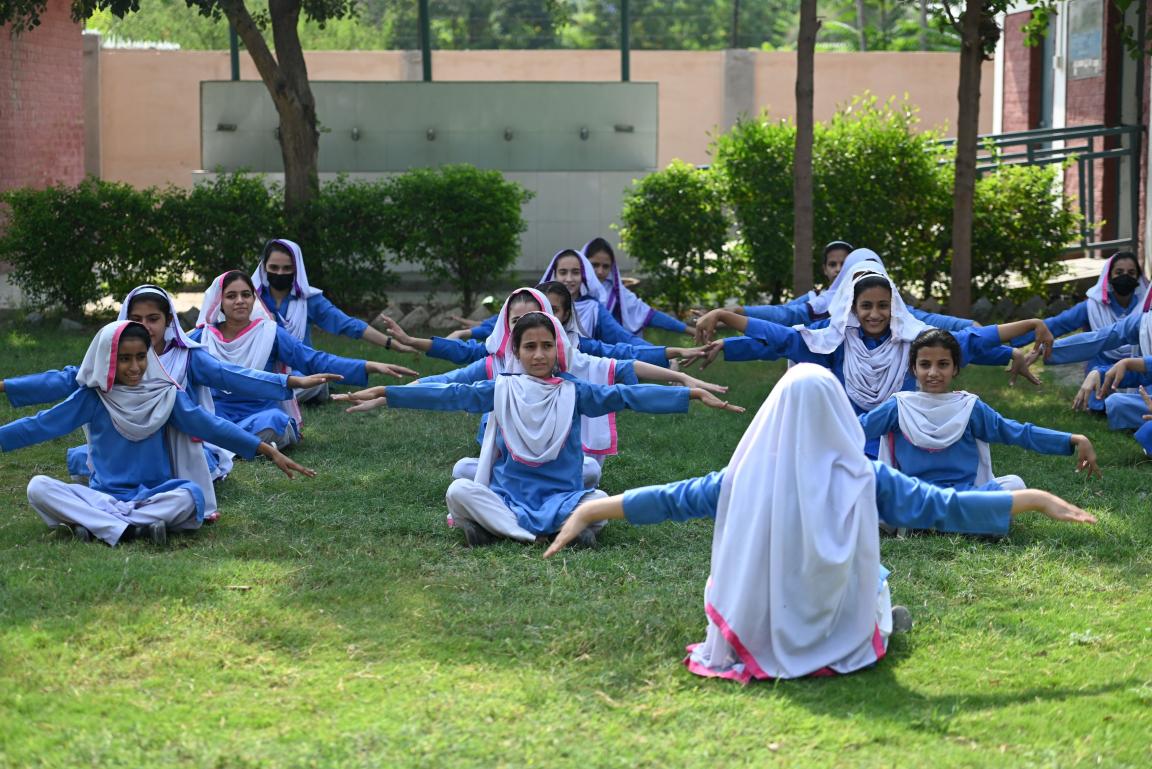  A group of female students in school uniform participating in an outdoor school activity.