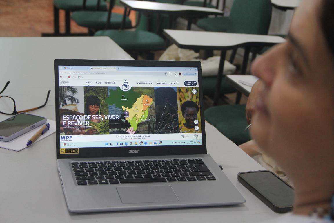 uma mulher está com a tela de computador aberta na plataforma de territórios tradicionais 