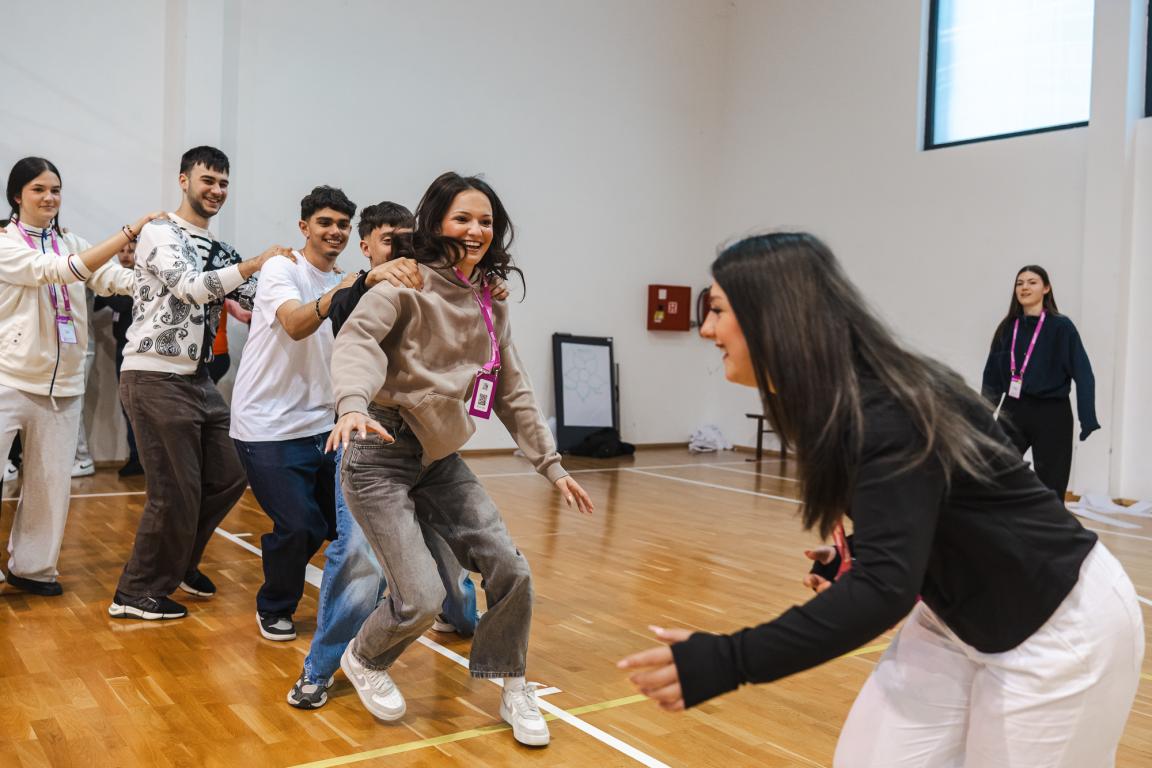 Young participants smiling and taking part in a lively teamwork activity during a Superschools exchange.