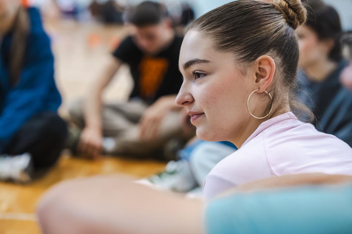 A young participant listening attentively during a Superschools group activity.