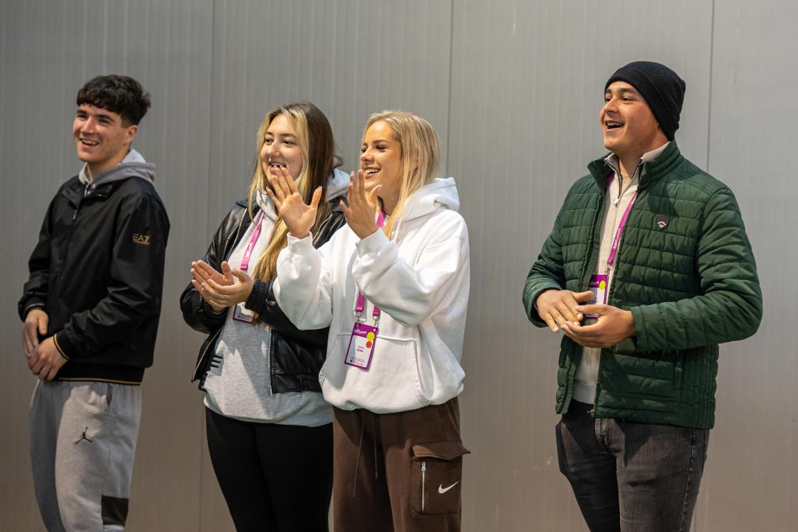 Young participants smiling and reacting together during a Superschools group activity.