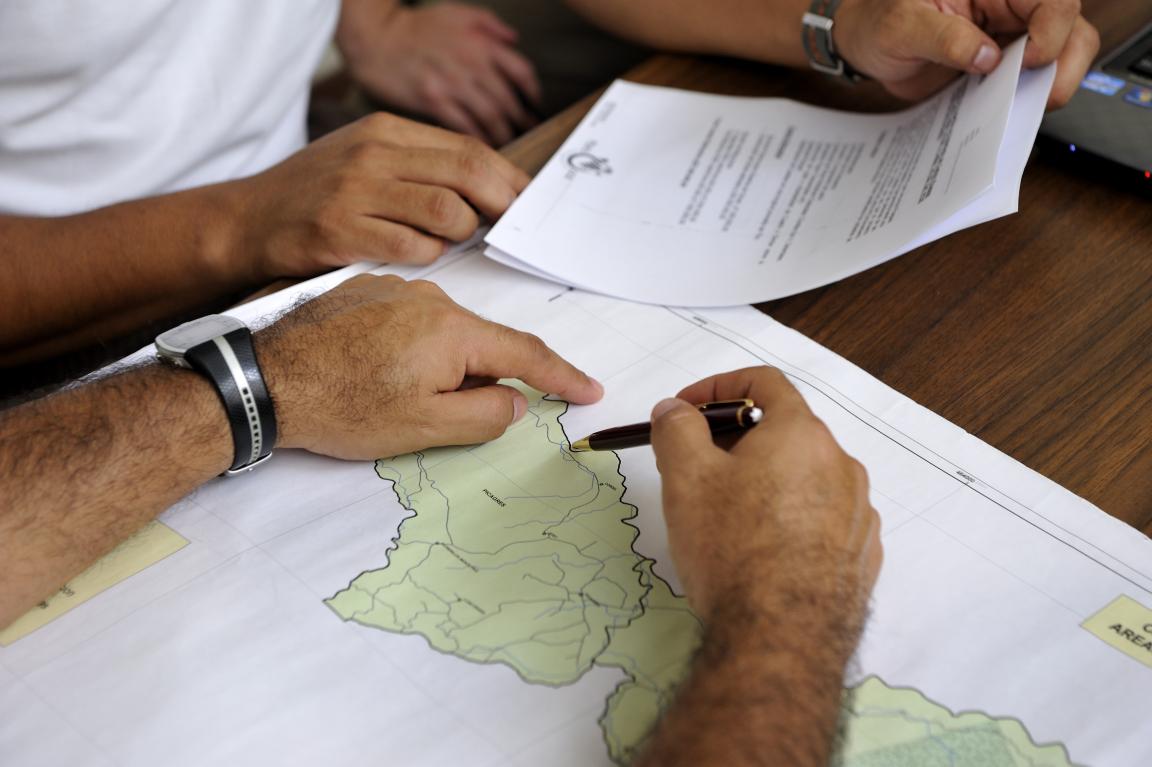 Personas señalas un punto en un mapa
