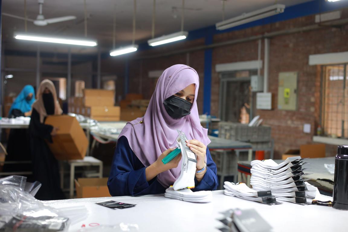 A woman trainee is shown packing a pair of socks