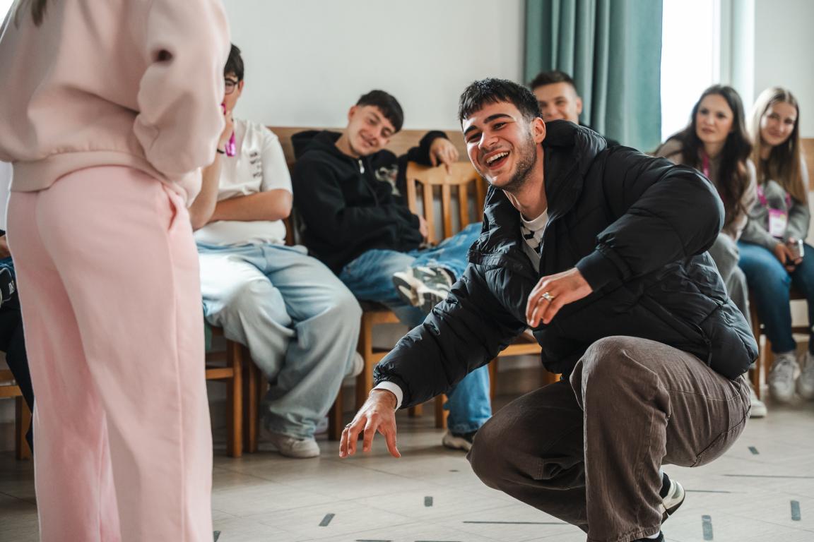 Young participant taking part in an interactive Superschools exchange activity, with a student smiling in the foreground.