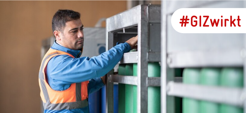 Ein Mann arbeitet mit Wasserstoffflaschen in einem Stahlbehälter.
