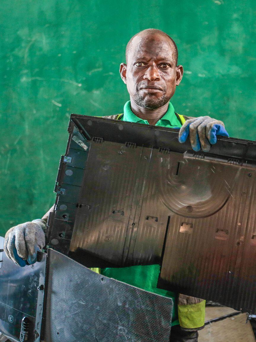 Mann entsorgt Gehäuseteile von Elektrogeräten