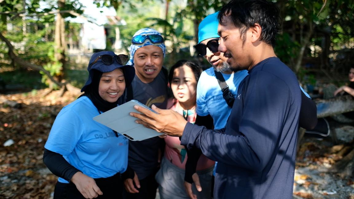 Gruppe von Menschen schaut gemeinsam auf ein Dokument