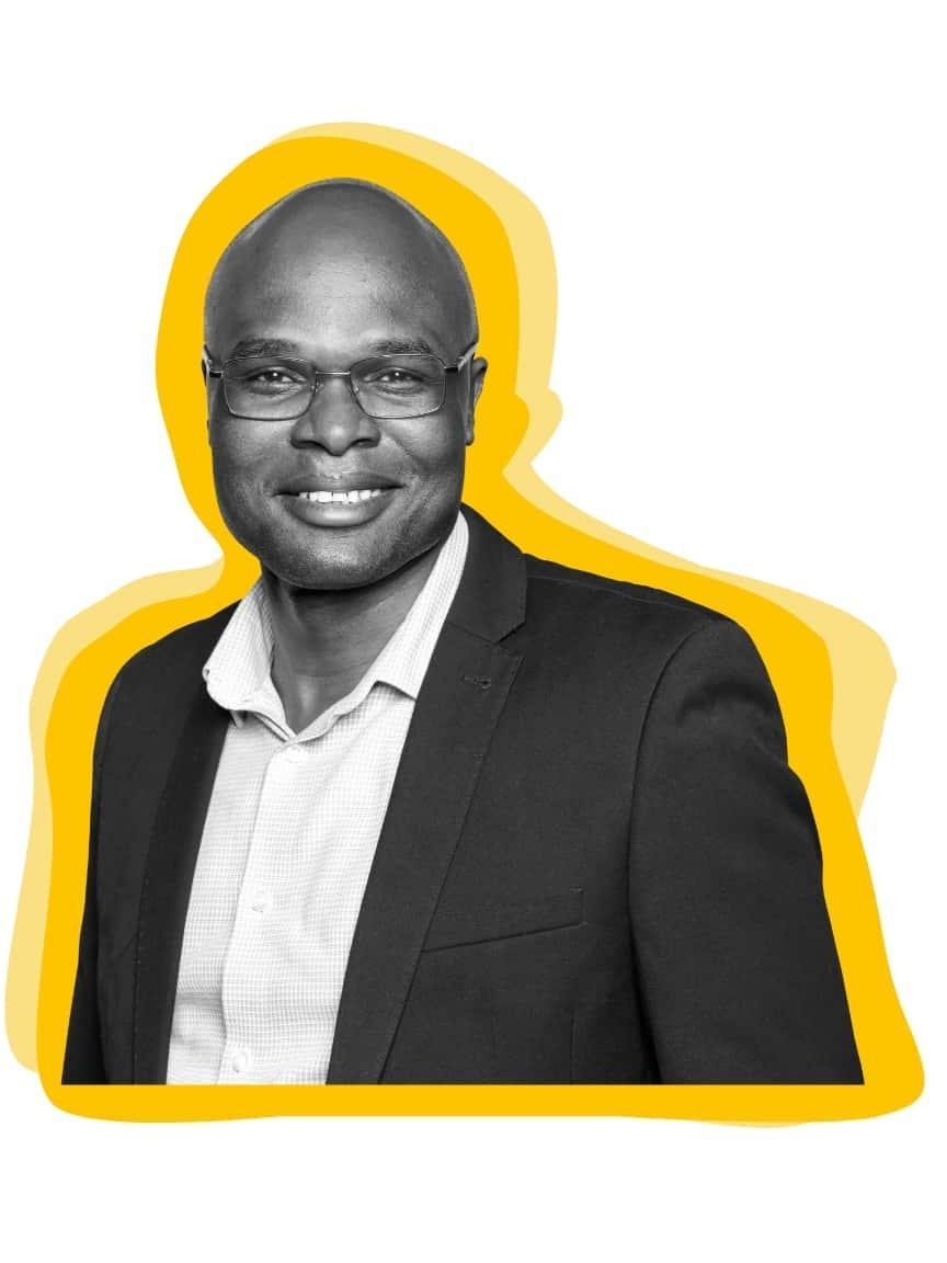 Schwarz-weiß-Porträt eines Mannes in einem dunklen Blazer, mit gelbem grafischem Hintergrund.