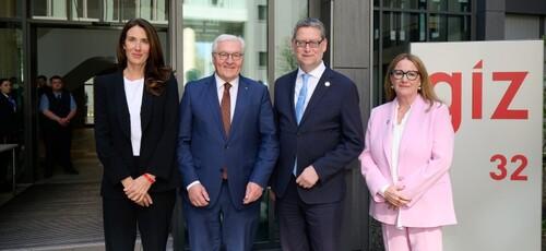 German Federal President Frank-Walter Steinmeier standing in front of the entrance to GIZ’s building in Bonn with the company’s managing directors Anna Sophie Herken, Thorsten-Schäfer Gümbel and Ingrid-Gabriela Hoven.