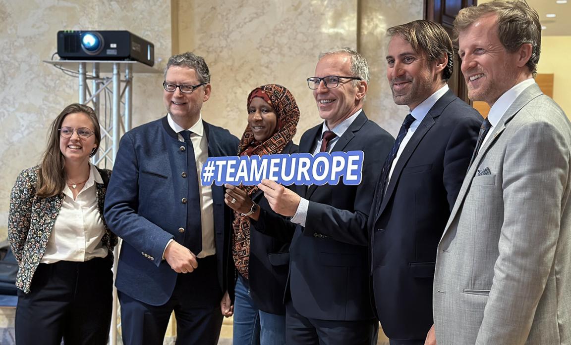 Six people posing together for a group photo, one person in the center holding a sign reading "#TEAMEUROPE".