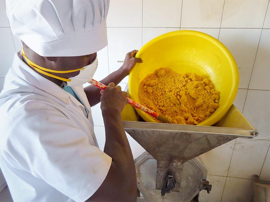 Picture of a trainee at Elisabeth Preira's company, learning how to process food.
