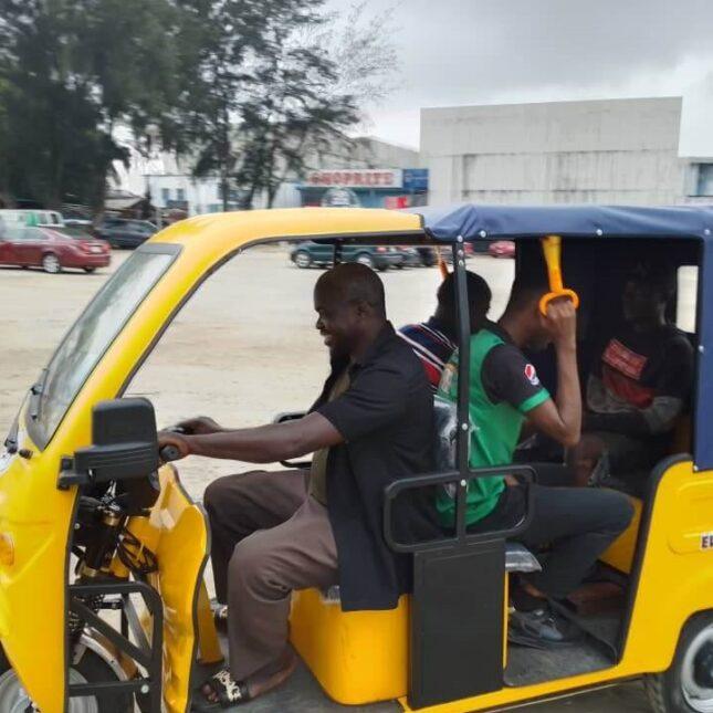 Ein Mann steuert ein Elektrofahrzeug mit drei Insassen.