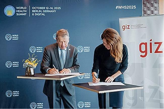 Prof. Dr. Heyo Kroemer, Vorstandsvorsitzender der Charité, und Anna Herken, Mitglied des Vorstands der GIZ, unterzeichnen ein Vertrag.