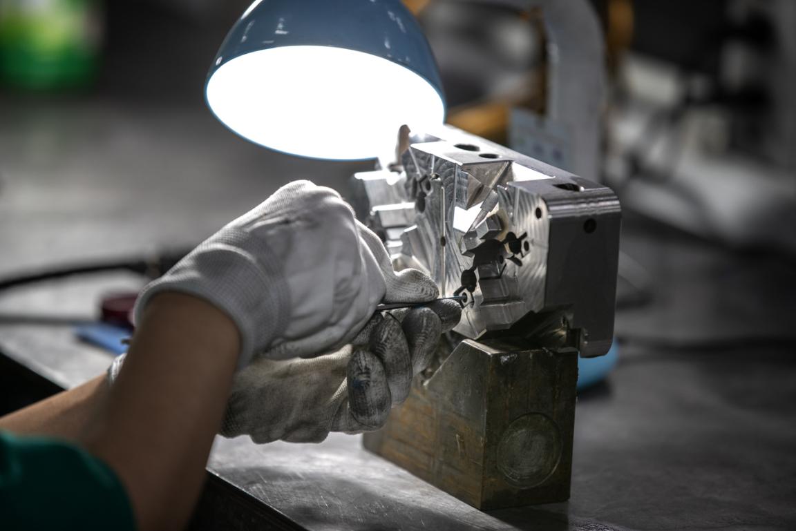 Worker inspecting a mold for plastic products at An Phu Viet Plastics The project "Initiative for Global Solidarity (IGS)" supports producers in selected sourcing markets for electronics and T&G products to fulfill the inc
