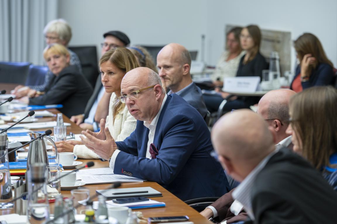 Company representatives sit round a table and discuss
