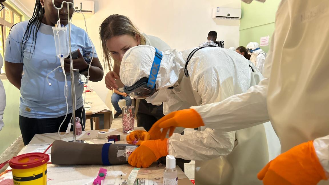 In einem Training lernt eine Gesundheitsfachkraft, wie sie einen Ebola-Patienten mit Schutzausrüstung behandelt.