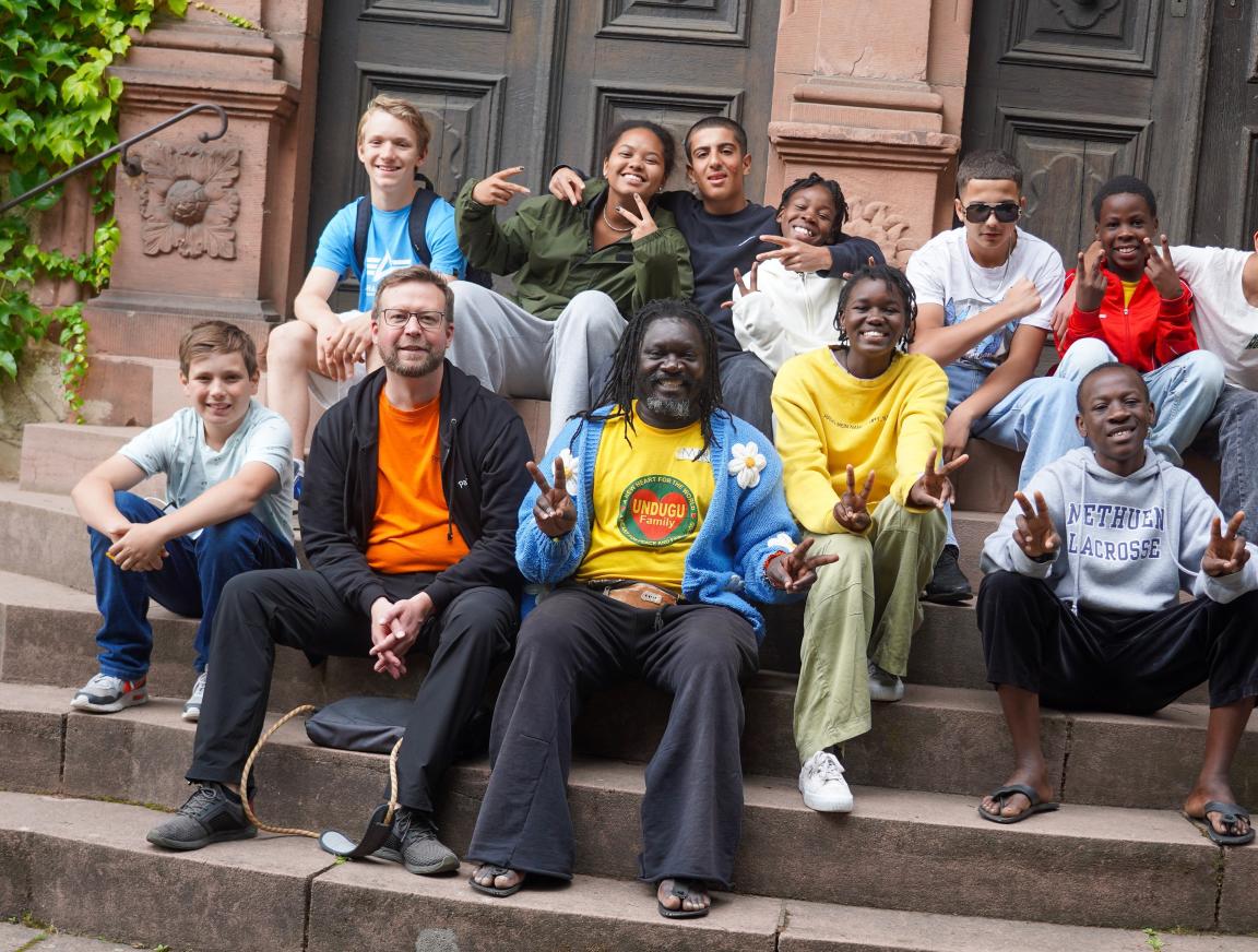 A group of teenagers is sitting on some steps