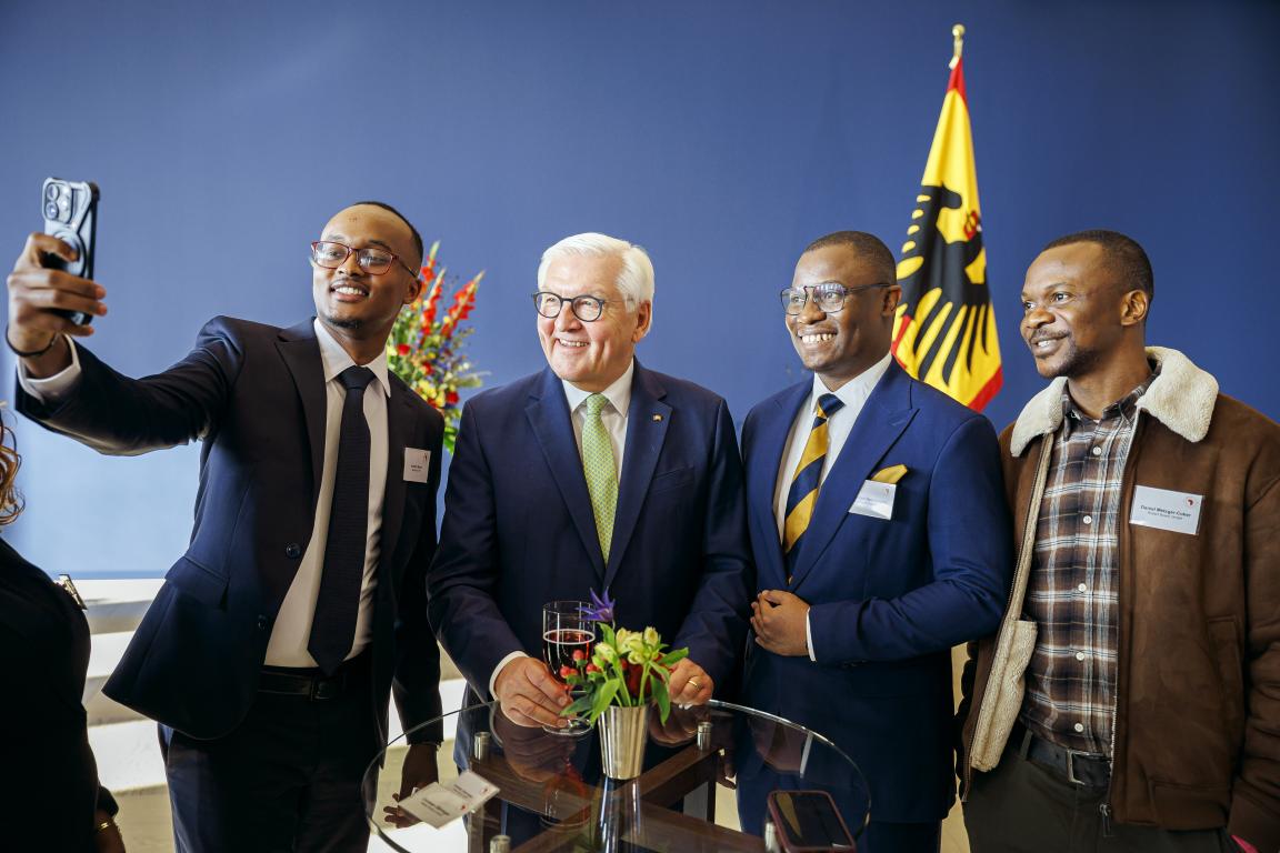 Drei der Stipendiaten machen ein Selfie mit Bundespräsident Frank-Walter Steinmeier im Schloss Bellevue. Alle grinsen ins Smartphone.