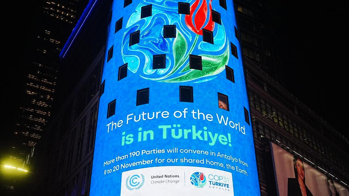 Night view of a blue LED building facade showing the slogan "The Future of the World is in Türkiye!" and the logos of UN Climate Change and COP31 Antalya.