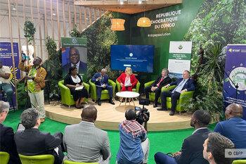 Lors de la COP27, cinq personnes assises sur une estrade discutent.