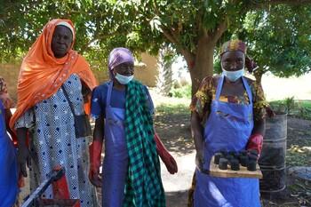 Une femme tient une planche en bois sur laquelle figure du charbon écologique.