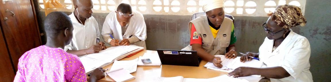 Assis·e·s à une table, des professionnel·le·s de santé consultent des données.