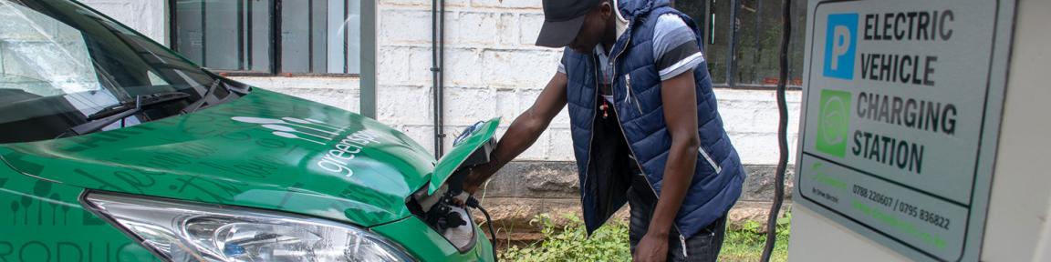 Ein Mann lädt in Kenia sein Elektroauto an einer Ladestation auf