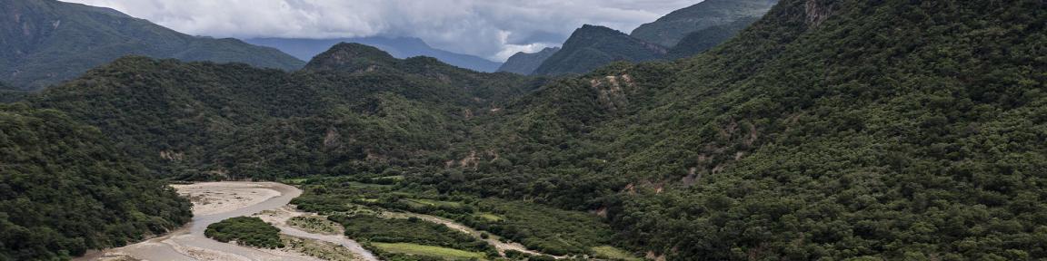 Ein Fluss fließt durch eine Hügellandschaft.