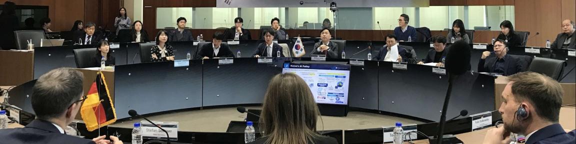 Teilnehmer*innen eines Treffens des deutsch-koreanischen Digitaldialogs sitzen in einem Konferenzraum.