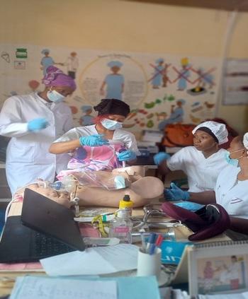 Quatre professionnelles de santé sont assises autour d'un mannequin de gynécologie et d’obstétrique.