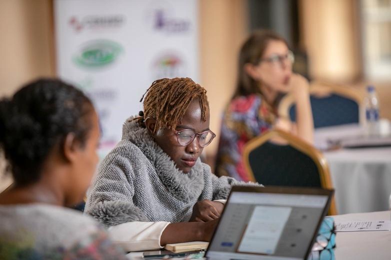 Three women sit at tables.
