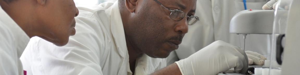 Männer in Kitteln arbeiten in einem Labor.