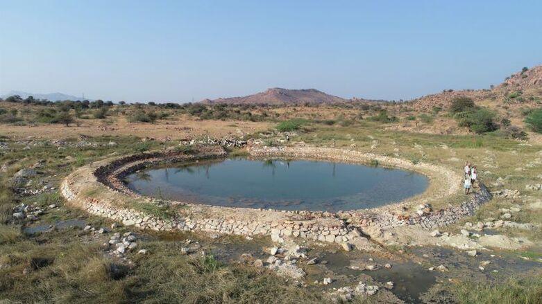 People standing by a completed water reservoir in a dry environment. Copyright: GIZ/Travelling Tripods