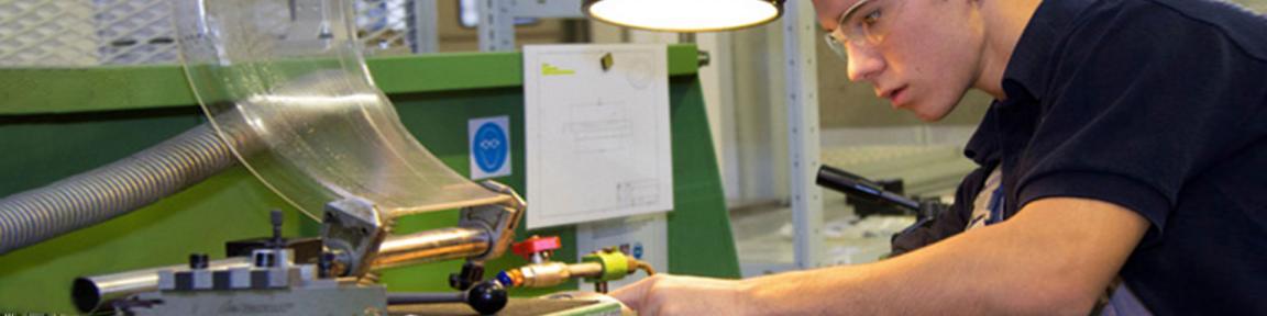 Ein junger Mann arbeitet in einer Werkstatt.