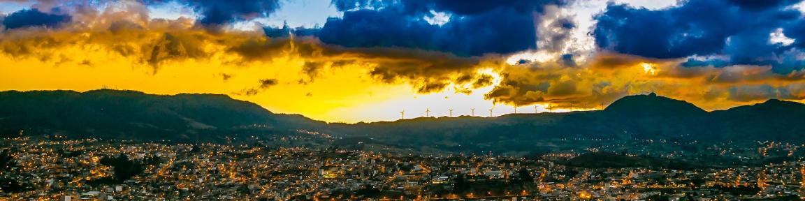 Luces sobre los tejados de una ciudad durante el crepúsculo.